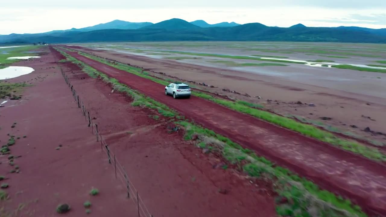 A pickup truck running across open desert and mountain roads